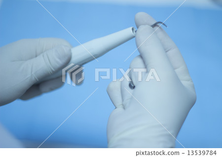 Dental nurse attaching ultrasound teeth cleaning attachment 13539784