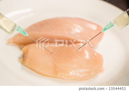 Food scientist injecting raw chicken 13544451