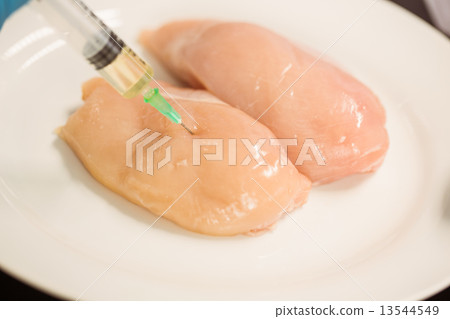 Food scientist injecting raw chicken Food scientist injecting raw chicken 13544549
