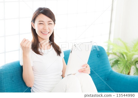觀看一種片劑的婦女在屋子裡 觀看一種片劑的婦女在屋子裡 13544990