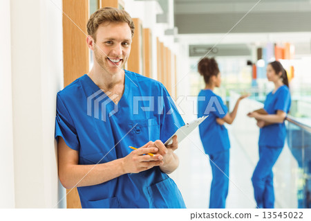 Medical student smiling at camera in hallway Medical student smiling at camera in hallway 13545022