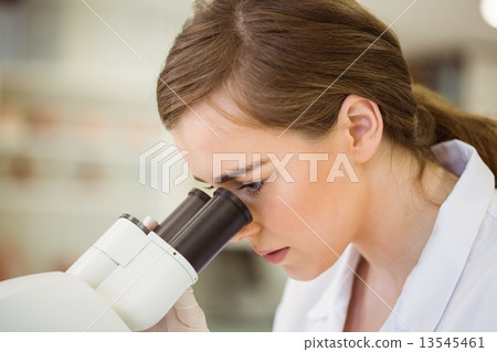 Young scientist working with microscope 13545461