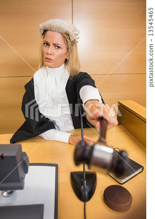 Stern judge pointing her hammer 13545465