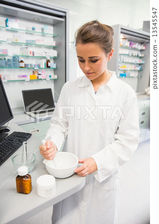 Junior pharmacist mixing a medicine 13545547
