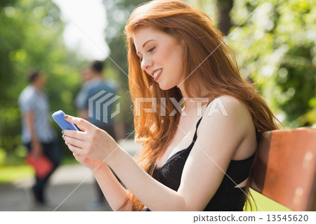 Pretty student sending a text outside 13545620
