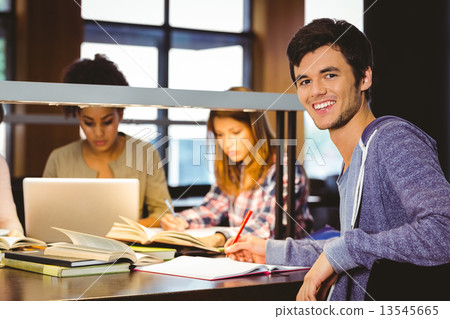 Student looking at camera with his classmates behind him 13545665