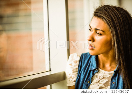 Pretty brunette sitting alone unsmiling Pretty brunette sitting alone unsmiling 13545667