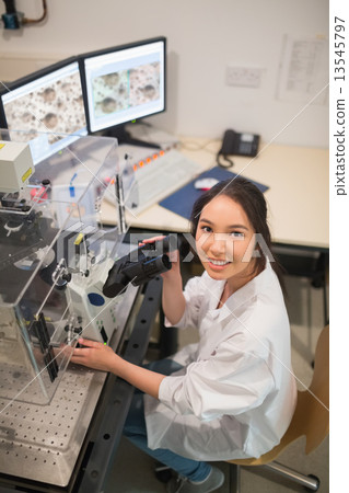 Biochemistry student using large microscope and computer Biochemistry student using large microscope and computer 13545797