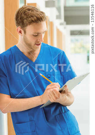 Medical student taking notes in hallway 13546116