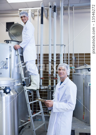 Men looking at the camera while on standing on the ladder 13546272