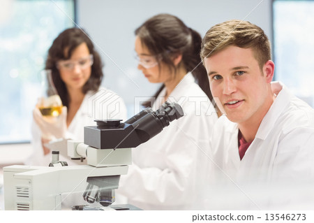 Science student looking through microscope in the lab Science student looking through microscope in the lab 13546273