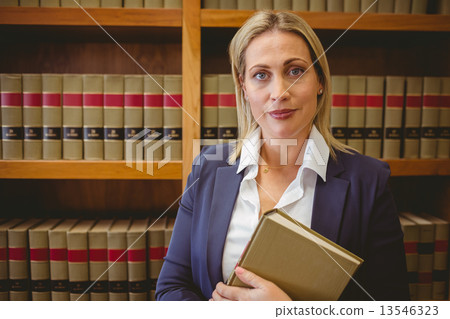 Portrait of a librarian posing and holding a book Portrait of a librarian posing and holding a book 13546323