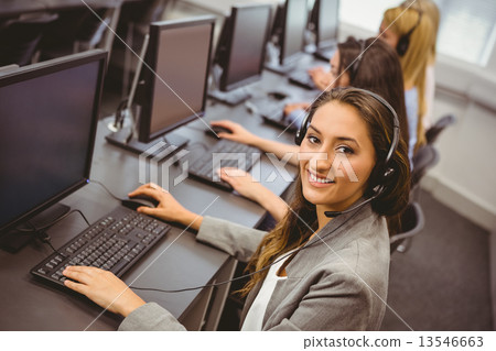 Smiling call centre agent talking on the headset Smiling call centre agent talking on the headset 13546663