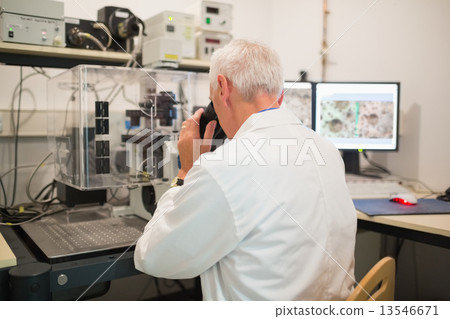 Biochemist using large microscope and computer Biochemist using large microscope and computer 13546671