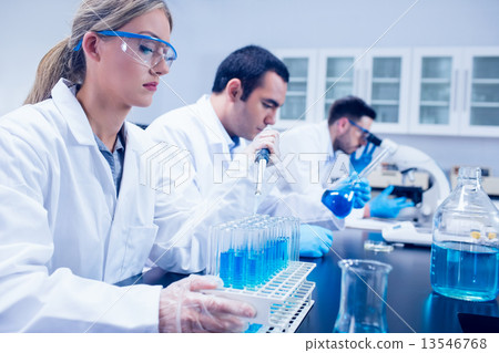Science student using pipette in the lab to fill test tubes Science student using pipette in the lab to fill test tubes 13546768