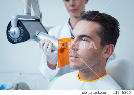Serious young man undergoing dental checkup Serious young man undergoing dental checkup 13546800