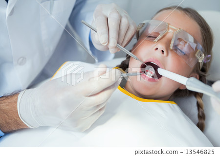 Close up of girl having her teeth examined 13546825