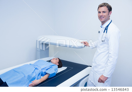Smiling doctor doing a radiography on a patient 13546843