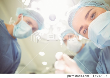Team of surgeons working together 13547104