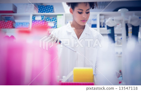 Pretty science student using pipette Pretty science student using pipette 13547118