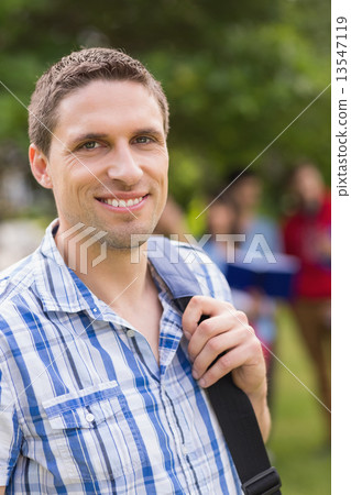 Happy student smiling at camera outside on campus Happy student smiling at camera outside on campus 13547119