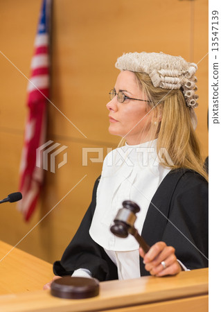 Stern judge sitting and listening 13547139