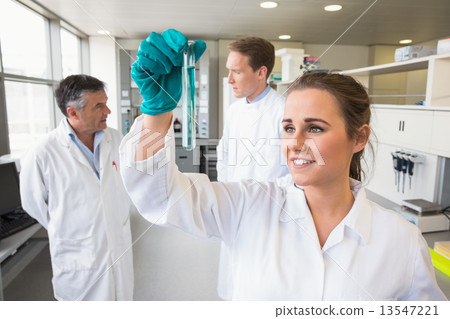 Young scientist holding up test tube Young scientist holding up test tube 13547221