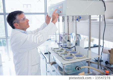Scientist with safety glasses using the machine 13547278
