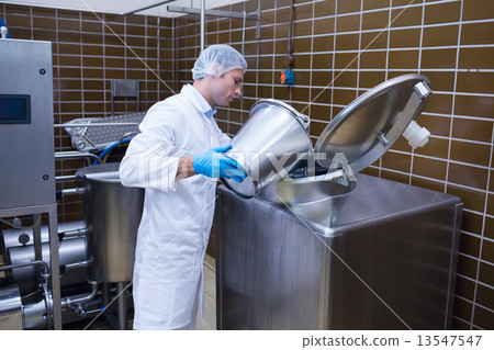 Smiling man in lab coat pouring something on the machine 13547547