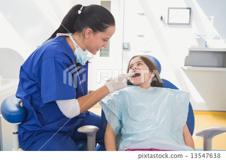 Pediatric dentist examining her young patient 13547638