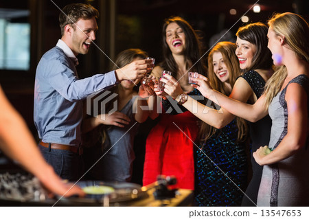 Happy friends drinking shots by the dj booth Happy friends drinking shots by the dj booth 13547653