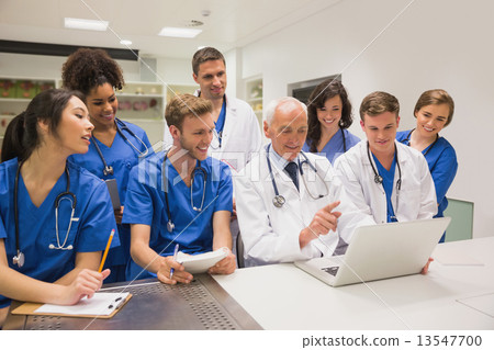 Stock Photo: Medical students and professor using laptop