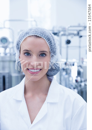 Portrait of a smiling scientist wearing hair net 13547864