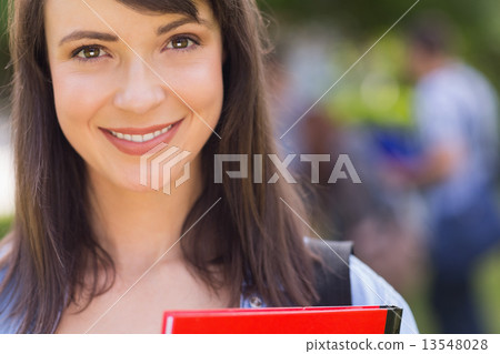Pretty student smiling at camera outside on campus Pretty student smiling at camera outside on campus 13548028