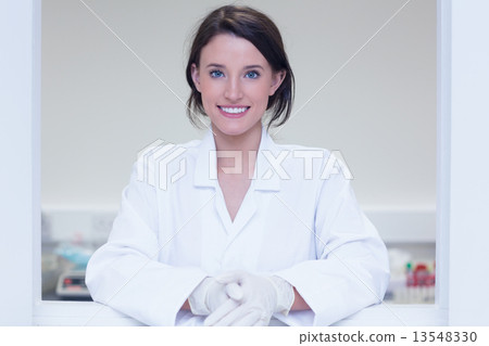 Female biologist smiling at the camera out the window Female biologist smiling at the camera out the window 13548330
