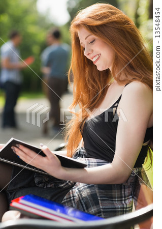 Pretty student studying outside on campus Pretty student studying outside on campus 13548454