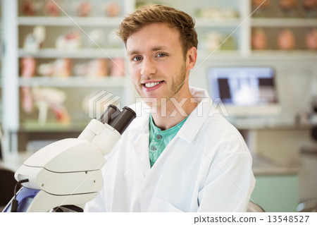 Young scientist working with microscope 13548527