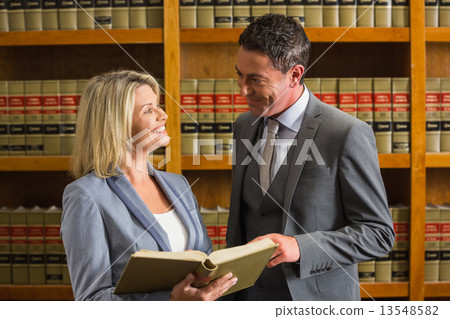 Lawyers reading book in the law library 13548582