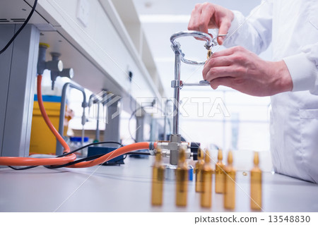Close up of a biochemist sealing a vial Close up of a biochemist sealing a vial 13548830