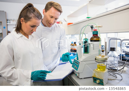 Young scientists conducting an experiment together Young scientists conducting an experiment together 13548865