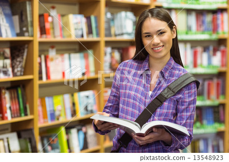 Smiling university student holding textbook 13548923
