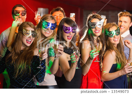Friends in masquerade masks drinking champagne Friends in masquerade masks drinking champagne 13549073