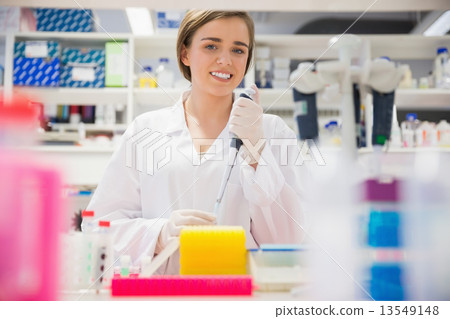 Pretty science student using pipette 13549148