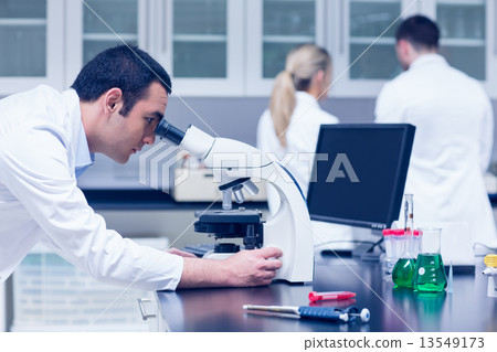 Science student working with microscope in the lab 13549173
