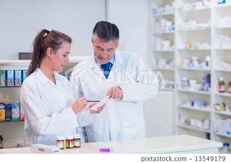 Pharmacist and his trainee working together 13549179