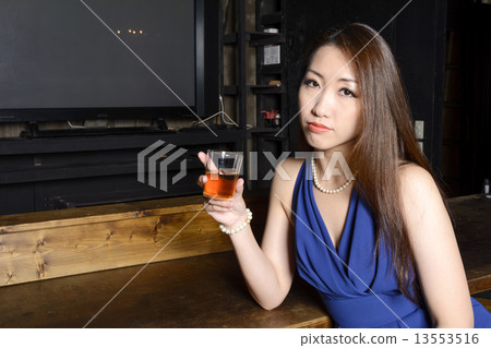 一件燕尾服的一名婦女與在櫃檯的一塊玻璃 13553516