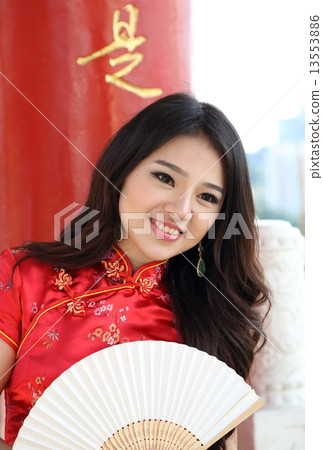 Woman wearing Chinese Chenogsam holding hand fan at Temple Woman wearing Chinese Chenogsam holding hand fan at Temple 13553886