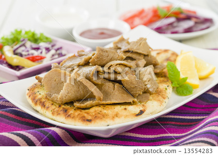 Donner Meat on Naan - Slices of donner meat on a flatbread  13554283
