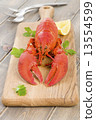 Lobster and lemon wedges on a chopping board.  13554599