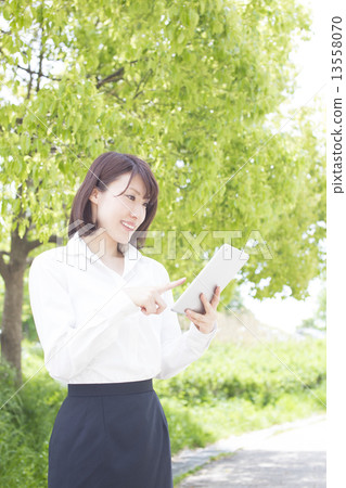 女商人觀看的片劑在公園 女商人觀看的片劑在公園 13558070